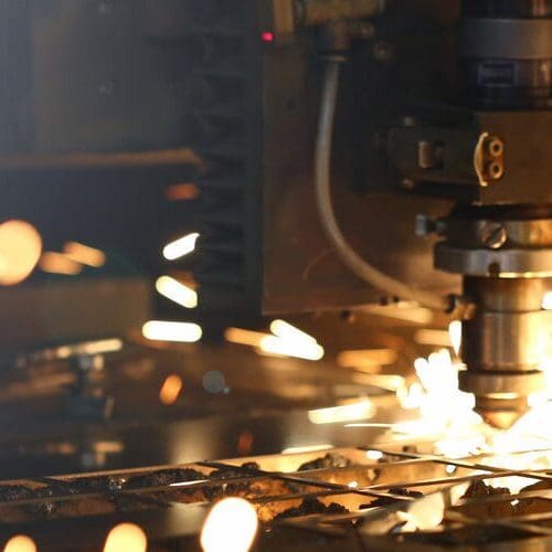 Sparks fly out machine head for metal processing laser metal on metallurgical plant background. Manufacturing finished parts for automotive production concept
