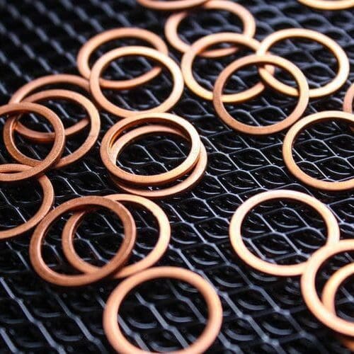 copper washers on black metal mesh background